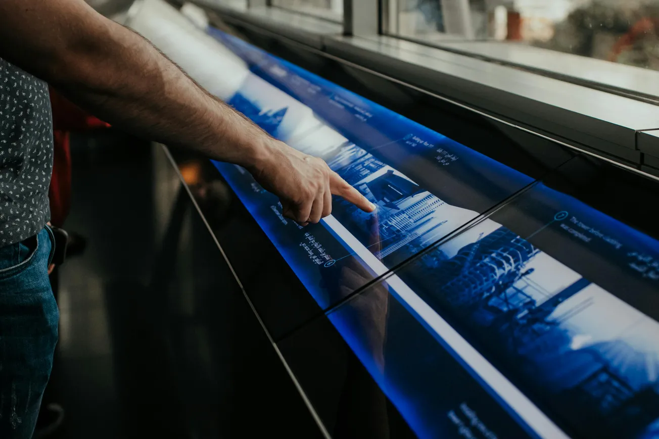 Customer using an interactive touchscreen display for digital product browsing in a retail store.